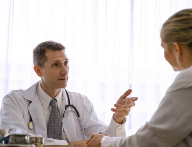 Doctor is checkup woman ‘s health at hospital. He explains about her health. Health care and medicine concept.