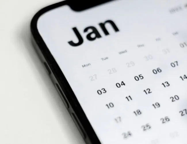 A smartphone showcasing an online scheduling app, zeroed in on the digital calendar for January. The visible date seems to be early in the month. Resting at a gentle angle on a light surface, it offers a glimpse into organized planning.